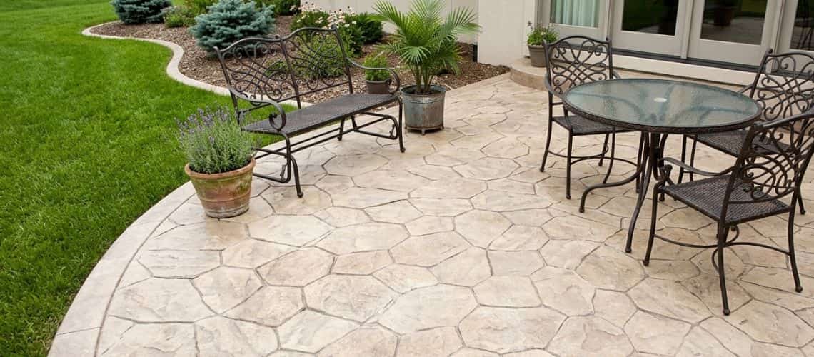 Professional stamped concrete patio installation with a flagstone texture